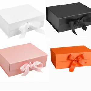 Puede incluir: Cuatro cajas de regalo con tapas, cada una atada con una cinta. Las cajas son blancas, negras, rosas y naranjas.