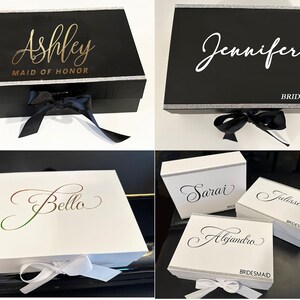 Puede incluir: Cuatro cajas de regalo negras y blancas con un borde plateado y una cinta. Las cajas est&aacute;n decoradas con los nombres "Ashley Maid of Honor", "Jennifer Bridesmaid", "Sarai", "Julissa Bridesmaid" y "Alejandro Bridesmaid".