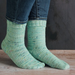 May include: A pair of green and white speckled socks with a ribbed texture.