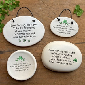 May include: Three white ceramic oval-shaped signs with a green shamrock design and the text "Good Morning, this is God. Today I'll be handling all your problems..... So sit back, relax and leave everything to me."