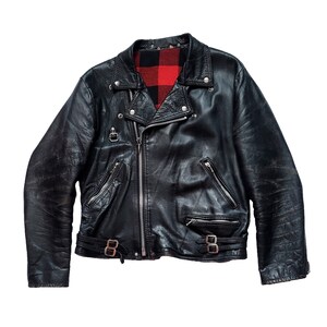 May include: A black leather motorcycle jacket with a red and black plaid lining. The jacket has a zipper closure, two pockets on the front, and a zippered pocket on the left sleeve.