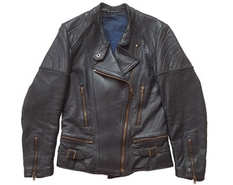 May include: A black leather motorcycle jacket with a zipper closure and multiple pockets. The jacket has a quilted design on the shoulders and sleeves.