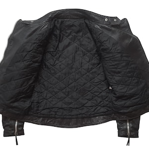May include: Black leather jacket with a quilted lining. The jacket has a zipper closure and two pockets on the front.