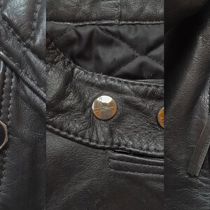 May include: Close-up of a black leather jacket with silver zippers and a gold eagle logo on the zipper pull. The jacket has a quilted lining and a snap button closure.