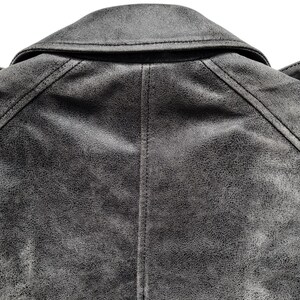 May include: A gray leather jacket with a distressed look. The jacket has a collar and a zipper closure.