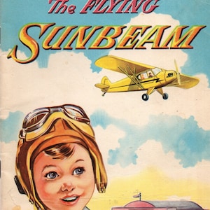 May include: A vintage book cover illustration featuring a yellow airplane with the title "The FLYING SUNBEAM" in bold, colorful letters. A young boy wearing a brown leather aviator helmet and goggles looks up at the plane against a blue sky with white clouds.