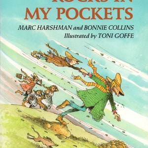 May include: A colorful illustration of a group of people running down a hill with rocks in their pockets. The book cover features the title "Rocks in My Pockets" by Marc Harshman and Bonnie Collins, illustrated by Toni Goffe.