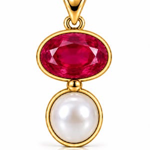 May include: A gold pendant featuring a faceted oval-shaped deep pink gemstone set above a round white pearl. The pendant includes a polished gold bail at the top, connecting the two stones in a vertical arrangement with a smooth gold frame.