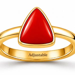 May include: A gold ring featuring a smooth, triangular red stone set in a polished gold bezel. The band is solid gold and includes the word Adjustable printed in black on the inner surface, indicating the ring can be resized for a custom fit.