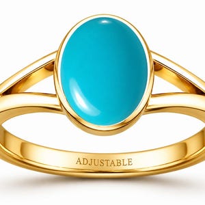 Op de afbeelding: Een gouden ring met een gladde, ovaalvormige turkoois steen gezet in een gepolijste gouden zetting. De ringband heeft een gespleten ontwerp dat aansluit op de centrale zetting. Het woord ADJUSTABLE is gegraveerd aan de binnenzijde van de ring.