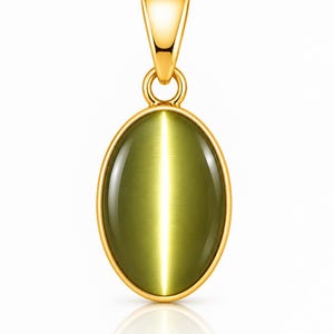 Puede incluir: Un colgante de forma ovalada con una piedra ojo de gato de color verde oliva liso, engastada en un marco de metal dorado pulido. El colgante incluye una anilla a juego en tono dorado en la parte superior para sujetarlo a una cadena.