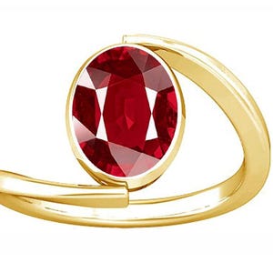 May include: A gold ring with a large, oval-shaped ruby gemstone. The ring has a simple, modern design.