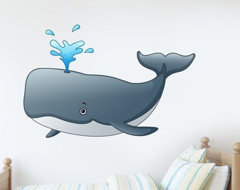 May include: A cartoon whale with a blue water spout on top of its head. The whale is gray and has a white belly. The whale is on a white wall above a wooden bed with a striped blue and white bedspread.