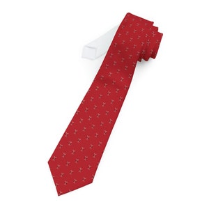 May include: A red tie with a white pattern of repeated small figures.