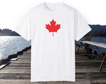 Puede incluir: Camiseta blanca con un diseño de hoja de arce canadiense roja.