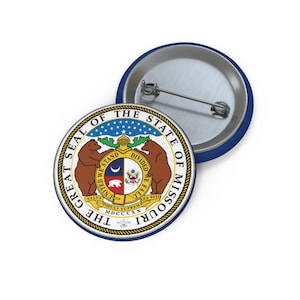 May include: A blue and white button featuring the Great Seal of the State of Missouri. The seal depicts two bears standing on either side of a shield with a crescent moon, a star, and a bear cub. The text "The Great Seal of the State of Missouri" is written around the outside of the seal.