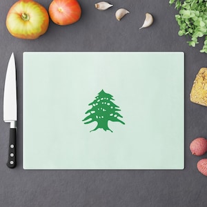 May include: A light green cutting board with a green cedar tree design. The cutting board is made of a durable material and is perfect for preparing meals.