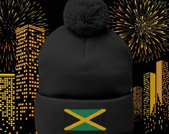 May include: Black beanie with a fluffy pom pom on top and a yellow, green, and black Jamaican flag design on the front.