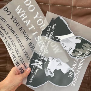 Puede incluir: Varias hojas transparentes con texto impreso y diseños gráficos. Una hoja dice "DO YOU KNOW WHAT I SEE DUMB PEOPLE EVERYWHERE." Otra hoja tiene un gráfico de una cara y el texto "THEY WALK AROUND LIKE EVERYONE ELSE THEY DON'T KNOW THEY'RE DUMB."