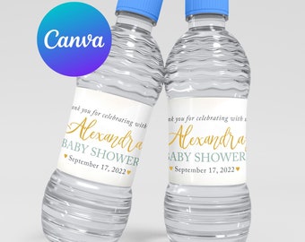 May include: Two clear plastic water bottles with blue caps and white labels. The labels have a gold cursive font that says "Thank you for celebrating with Alexandra Baby Shower September 17, 2022".