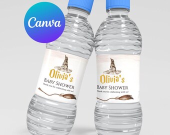 May include: Two clear plastic water bottles with labels that say "Olivia's Baby Shower" and feature a witch's hat and a broom. The labels are beige with gold lettering and a watercolor-style illustration.