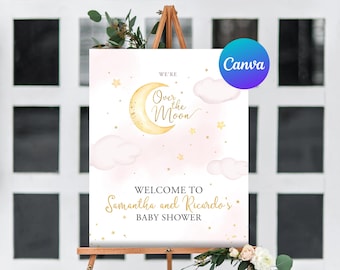 May include: A white welcome sign with gold lettering that reads "We're Over the Moon" and "Welcome to Samantha and Ricardo's Baby Shower". The sign features a gold crescent moon, white clouds, and gold stars on a pink watercolor background.
