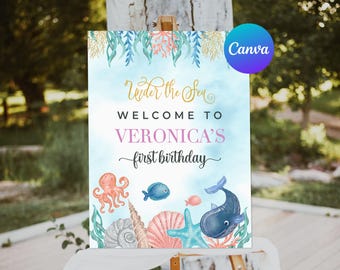 May include: A blue and white printable sign with the text "Under the Sea" and "Welcome to Veronica's first birthday". The sign features illustrations of a starfish, seashells, an octopus, a whale, and fish.