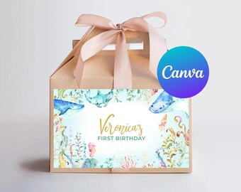 May include: A brown favor box with a gold ribbon and a sticker featuring a watercolor illustration of sea creatures and the text "Veronica's First Birthday".