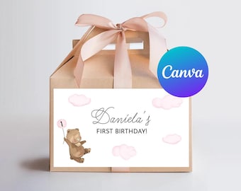 May include: A brown paper gift bag with a pink ribbon and a white label. The label has a cartoon bear holding a pink balloon with the number 1 on it. The label also says "Daniela's First Birthday!" with pink clouds in the background.