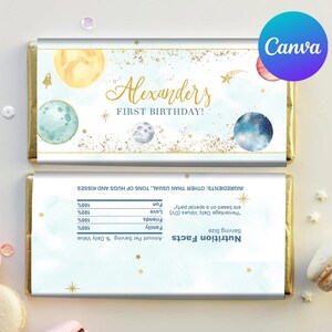 Puede incluir: Un envoltorio de barra de chocolate azul y dorado con temática espacial. Dice "Alexander's First Birthday!" y tiene planetas, estrellas y un cohete. La parte posterior del envoltorio tiene una etiqueta de información nutricional con un mensaje divertido y ligero.