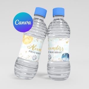 Puede incluir: Dos botellas de agua de plástico transparente con tapas azules y etiquetas personalizadas. Las etiquetas presentan un diseño de acuarela con estrellas doradas, lunas y el texto "Alexanders First Birthday!" y "Alexys First Birthday!"