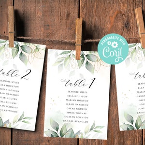 May include: Three white cards with green watercolour leaves and gold glitter. The cards are labelled "table 2", "table 1", and "table 7" and list names for each table.