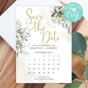 Op de afbeelding: Save the date-kaart met een aquarelbloemendesign in tinten groen en blauw. De kaart bevat een kalender met de datum in een gouden cirkel, en de tekst "Save the Date" in gouden schrift. De tekst "Voor de bruiloft van Olivia + James" en "Oktober 2023" is ook inbegrepen. De kaart is gepersonaliseerd met de tekst "Personaliseer met Corjl".