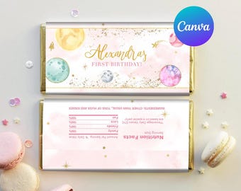 May include: Pink and gold chocolate bar wrapper with a space theme. The wrapper features planets, stars, and the text "Alexandra's First Birthday!"