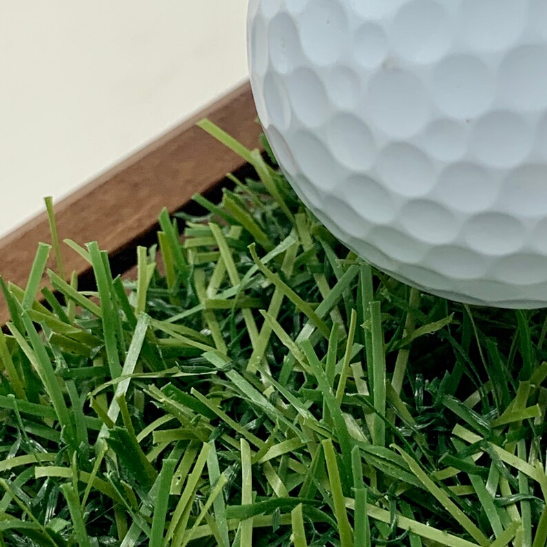 The golf scorecard a ball display holder is a handcrafted walnut display designed to showcase a golf ball and scorecard from your personal best round or hole-in-one. Featuring realistic fake grass under the golf ball on a tee, it’s a perfect way to commemorate your golfing achievements. Ideal for Father's Day, graduations, retirements, or golf trips, this unique gift is a stylish addition to any golfer’s home or office and makes a thoughtful gift for golf enthusiasts.