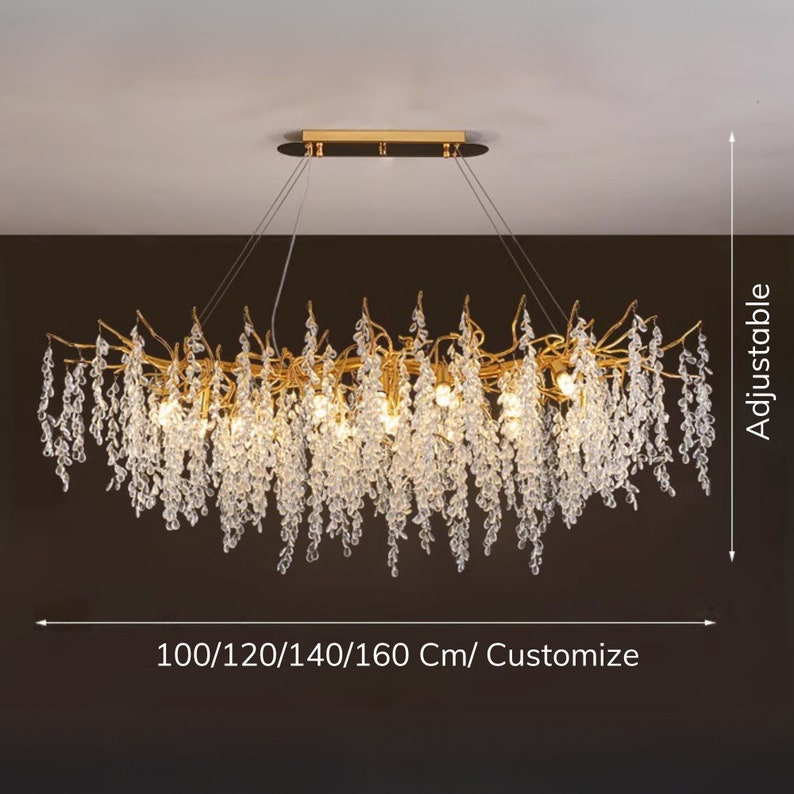 May include: Gold chandelier with crystal drops, featuring a branch-like design. The chandelier is adjustable in length, with options for 100, 120, 140, or 160 cm, or can be customised.