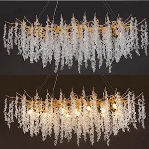 May include: A gold chandelier with crystal drops hanging from branches. The chandelier has a long, rectangular shape and is lit with multiple light bulbs.