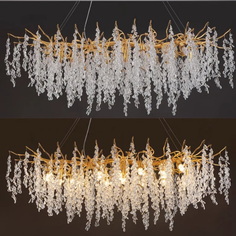 May include: A gold chandelier with crystal drops hanging from branches. The chandelier has a long, rectangular shape and is lit with multiple light bulbs.