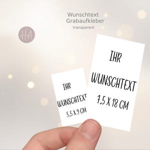 Może przedstawiać: Dwie białe prostokątne naklejki z czarnym napisem "IHR WUNSCHTEXT". Jedna naklejka ma wymiary 5,5 x 9 cm, druga 7,5 x 18 cm. Obraz zawiera również tekst "Wunschtext Grabaufkleber transparent".