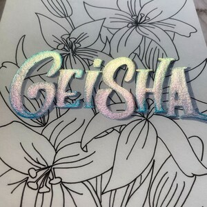 May include: A white background with black line drawings of lilies. The word "GEISHA" is written in iridescent blue and pink letters.