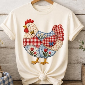May include: A cream-coloured t-shirt with a patchwork chicken design. The chicken features red gingham, blue floral, and dotted patterns, with embroidered details and butterfly accents. The shirt is knotted at the bottom.