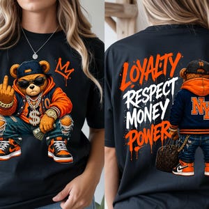 Może przedstawiać: Czarny t-shirt z kresk&oacute;wkowym misiem w okularach przeciwsłonecznych, czapce i złotym łańcuchu, pokazującym środkowy palec. Miś ma na sobie pomarańczowo-niebieską kurtkę i podarte dżinsy. Z tyłu koszulki widnieją słowa "Lojalność, Szacunek, Pieniądze, Władza."
