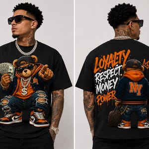 Może przedstawiać: Czarny t-shirt z kresk&oacute;wkowym misiem w okularach przeciwsłonecznych, złotym łańcuchem i pieniędzmi. Miś ma na sobie kurtkę, podarte dżinsy i trampki. Tył koszulki zawiera słowa "Lojalność, Szacunek, Pieniądze, Władza."