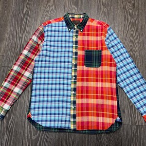 May include: A long-sleeve button-down shirt featuring a patchwork design of various plaid patterns in red, blue, orange, yellow, and green. The shirt includes a button-down collar, a single chest pocket, and a front button placket with white buttons.