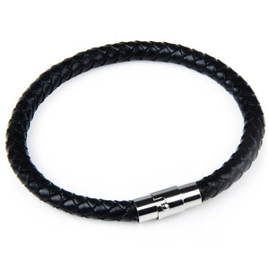 May include: A black braided leather bracelet with a silver magnetic clasp. The bracelet is circular and appears to be unworn. The leather is tightly woven, and the clasp is shiny.
