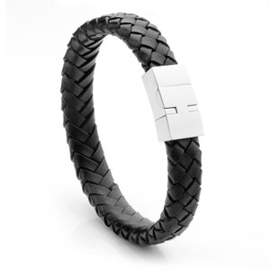 Peut inclure: Un bracelet en cuir noir avec un design tressé et un fermoir magnétique argenté.