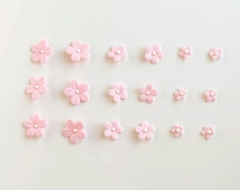 May include: Pink edible flower decorations with pearl centers, arranged on a white surface. The flowers vary in size and are ideal for cake decorating. The text "sweetserenebakelab" is visible at the top and "SWEET SERENE BAKE LAB" at the bottom.