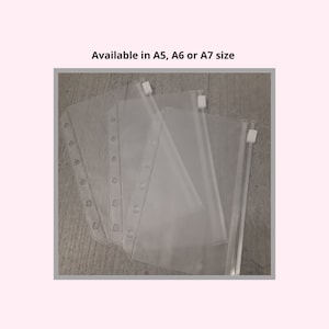 May include: Transparent plastic binder pouches with zip closures. The pouches have pre-punched holes for binder insertion. The text "Available in A5, A6 or A7 size" is printed above the pouches.