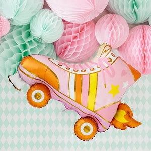 May include: A pink roller skate-shaped balloon with gold and yellow accents, star details, and orange wheels. The balloon is surrounded by pink and mint green honeycomb paper decorations, creating a festive party theme.