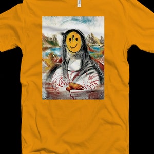 May include: A yellow t-shirt with a graphic of a painting of a person with a smiley face with three black dots above the eyes. The background of the painting is a landscape with mountains and water.
